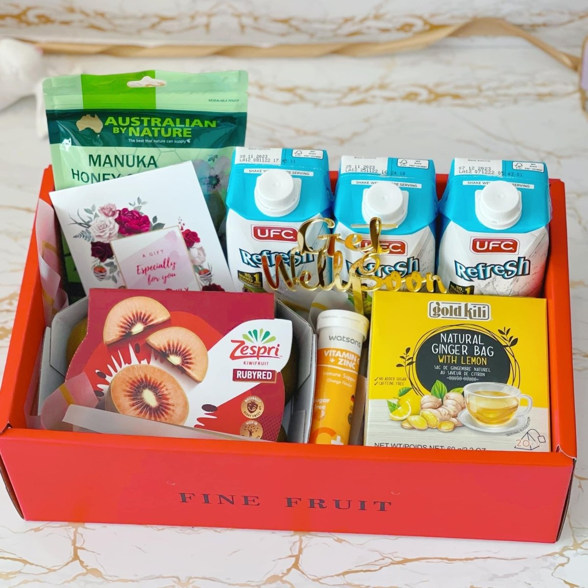 Get well soon hamper Singapore with Manuka honey lozenges, kiwi, ginger drink, coconut water and get well soon topper.
